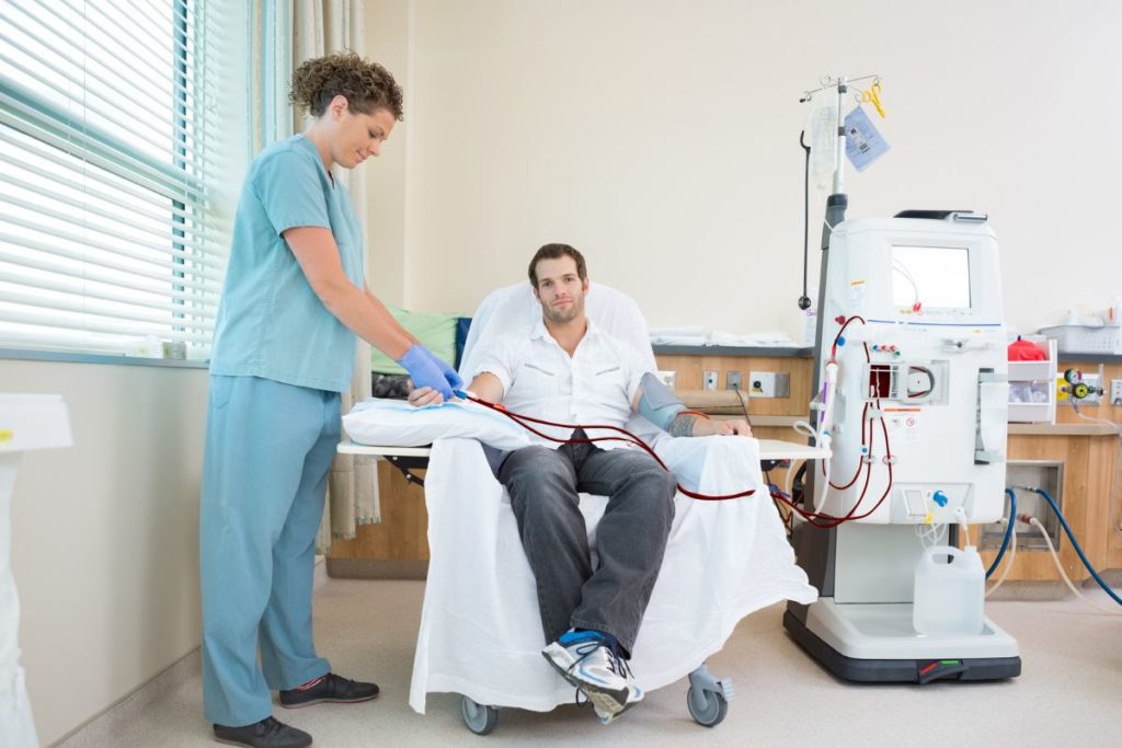 Dialysis professional with patient during travel dialysis jobs